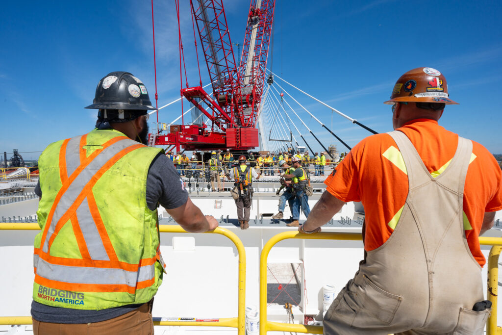 Celebrating the hands helping build - crane at the bridge construction site