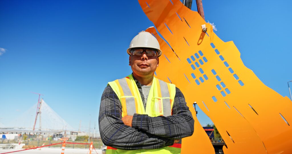 Construction worker standing infront of yellow/orange wall