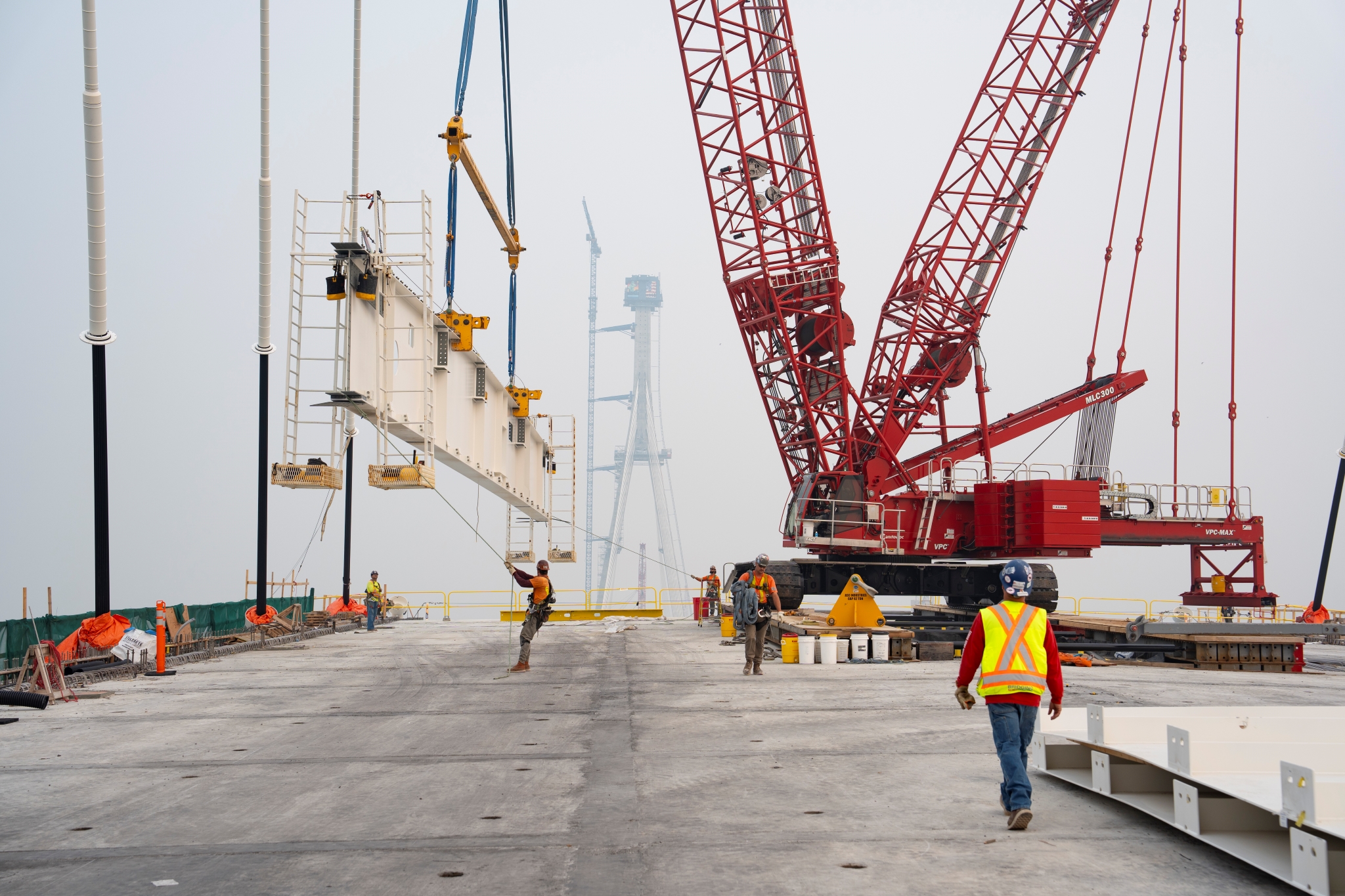red crane holding massive metal for construction workers